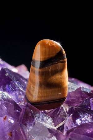 A Polished Tiger's Eye Stone on a Bed of Amethyst Crystals Journal de Cs Creations